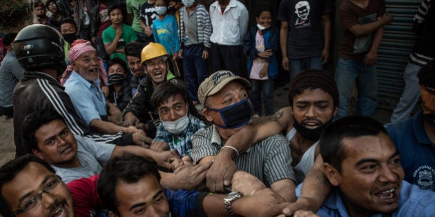 BHAKTAPUR, NEPAL - MAY 03: Men pull down a damaged building with a rope on May 3, 2015 in Bhaktapur, Nepal. A major 7.8 earthquake hit Kathmandu mid-day on Saturday, and was followed by multiple aftershocks that triggered avalanches on Mt. Everest that buried mountain climbers in their base camps. Many houses, buildings and temples in the capital were destroyed during the earthquake, leaving over 6000 dead and many more trapped under the debris as emergency rescue workers attempt to clear debris and find survivors. Regular aftershocks have hampered recovery missions as locals, officials and aid workers attempt to recover bodies from the rubble. (Photo by David Ramos/Getty Images)