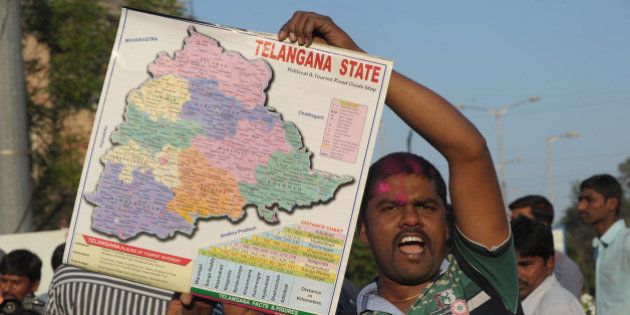 An Indian supporter of Telangana Rastra Samithi (TRS) party holds a map as he celebrates the planned creation of Telangana state in Hyderabad on February 18, 2014. Indian lawmakers in the lower house, the Lok Sabha, voted to pass a controversial bill creating the country's 29th state at parliament in the capital New Delhi on February 18. The bill must be passed by the upper house before becoming law. AFP PHOTO / Noah SEELAM (Photo credit should read NOAH SEELAM/AFP/Getty Images)