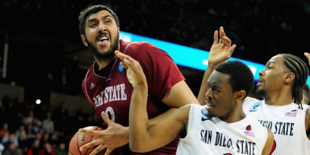 SPOKANE, WA - MARCH 20: Sim Bhullar #2 of the New Mexico State Aggies is defended by Xavier Thames #2 and Josh Davis #22 of the San Diego State Aztecs during the second round of the 2014 NCAA Men's Basketball Tournament at Spokane Veterans Memorial Arena on March 20, 2014 in Spokane, Washington. (Photo by Steve Dykes/Getty Images)