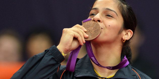 India's Saina Nehwal kisses her bronze medal after beating China's Wang Xin in their bronze medal women's singles badminton match at the London 2012 Olympic Games in London, on August 4, 2012. AFP PHOTO / ADEK BERRY (Photo credit should read ADEK BERRY/AFP/GettyImages)