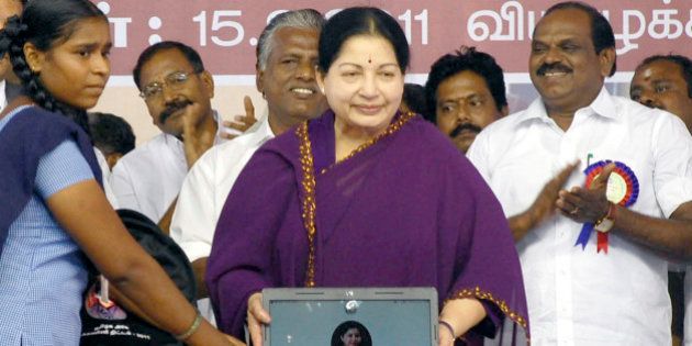 Leader of All India Anna Dravida Munnetra Kazhagam (AIADMK) party and Chief Minister of the southern Indian state of Tamil Nadu J. Jayalalithaa (C) presents a laptop computer to a student (L) during a ceremony in Chennai on September 15, 2011. The southern Indian state of Tamil Nadu on September 15 began a 2 billion USD giveaway of free laptops to every student in state-run schools and colleges over the next five years. AFP PHOTO/STR (Photo credit should read STRDEL/AFP/Getty Images)