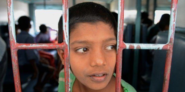 A rescued Indian child labourer looks on on board a Patna-bound express train at a railway station in Secunderabad on February 5, 2015. The children, rescued from bangle-making factories and other workshops in Secunderabad's twin city Hyderabad in the past ten days, are being sent back to their places of origin. Some 400 children hailing from India's Bihar, Uttar Pradesh and West Bengal states were rescued during raids conducted by the city police and labour department officials in different parts of the old city. AFP PHOTO / NOAH SEELAM (Photo credit should read NOAH SEELAM/AFP/Getty Images)