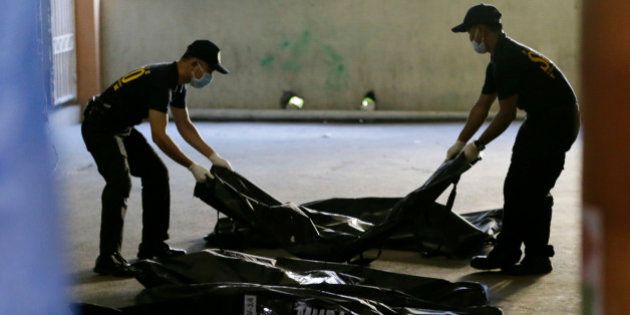 Members of Scene of the Crime Operatives of the Philippine National Police line up body bags containing the remains of victims Thursday, May 14, 2015, a day after a fire gutted Kentex rubber slipper factory in Valenzuela city, a northern suburb of Manila, Philippines. A fire gutted the factory, possibly killing dozens of workers who ran to the second floor in hopes of escaping only to become trapped by inferno, officials said. (AP Photo/Bullit Marquez)
