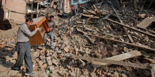 Nepalese people recover their belongings from earthquake destroyed buildings in Bhaktapur, Nepal, Thursday, May 14, 2015. The past three weeks have been misery for Nepal. On April 25, a magnitude-7.8 earthquake killed thousands of people, injured tens of thousands more and left hundreds of thousands homeless. Then, just as the country was beginning to rebuild, a magnitude-7.3 earthquake battered it again. (AP Photo/Bikram Rai)