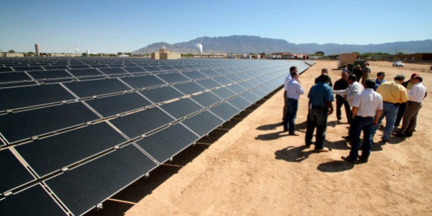 FILE - This April 20, 2011 file photo officials with Arizona-based First Solar and Public Service Company of New Mexico gather after the dedication of the utility's new 2-megawatt photovoltaic solar array in Albuquerque, N.M. The New Mexico House of Representatives on Thursday, March 12, 2105, narrowly approved a measure reducing the amount of renewable energy sources utilities would have to tap to provide electricity for their customers by 2020. (AP Photo/Susan Montoya Bryan,File)