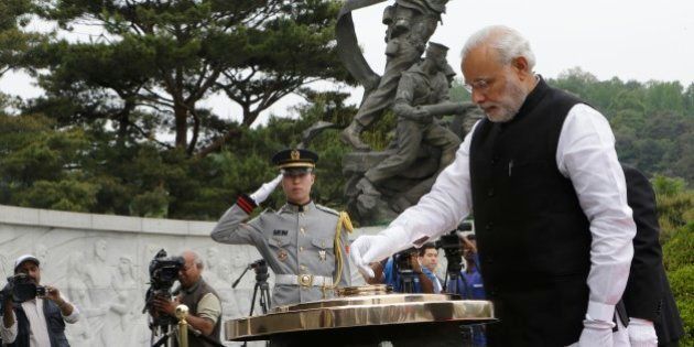Indian Prime Minister Narendra Modi, right, burns incense at the National Cemetery in Seoul, South Korea, Monday, May 18, 2015. Modi arrived Monday for a two-day visit to meet with South Korean President Park Geun-hye and to discuss economic ties and boost bilateral cooperation. (AP Photo/Ahn Young-joon)