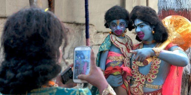 Indian artists dressed as monkey god Hanuman have a picture clicked on a mobile phone prior to Rama Navami festival at a temple in Bangalore on March 28, 2015. Rama Navami is a Hindu festival, celebrating the birth of the god Rama whom Hindus consider is the seventh incarnation of Lord Vishnu and is the oldest known Hindu god having human form. AFP PHOTO / Manjunath KIRAN (Photo credit should read Manjunath Kiran/AFP/Getty Images)