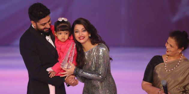 Former Miss World Aishwarya Rai, centre speaks on stage with husband Abhishek Bachchan and daughter Aaradhya Bachchan, during the Miss World 2014 final, on stage at the Excel centre in east London, Sunday, Dec. 14, 2014. (Photo by Joel Ryan/Invision/AP)