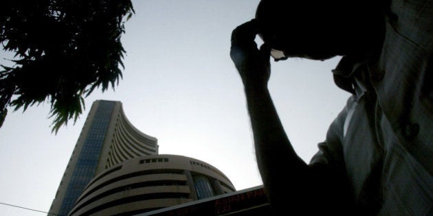 An unidentified person reacts as he watches a screen displaying the share prices outside the building of the Bombay Stock Exchange in Mumbai, India, Monday, April 2, 2007. Indian shares plunged nearly 5 percent Monday, as investors were spooked by fresh moves from the central bank to tighten monetary policy in a bid to rein in sizzling economic growth that has stoked inflation. The Bombay Stock Exchange's 30-share Sensex index tumbled 617 points, or 4.7 percent, to 12,455 points, while on the broader National Stock Exchange, the 50-company S&P Nifty index fell 4.9 percent to 3,634 points. (AP Photo/Gautam Singh)