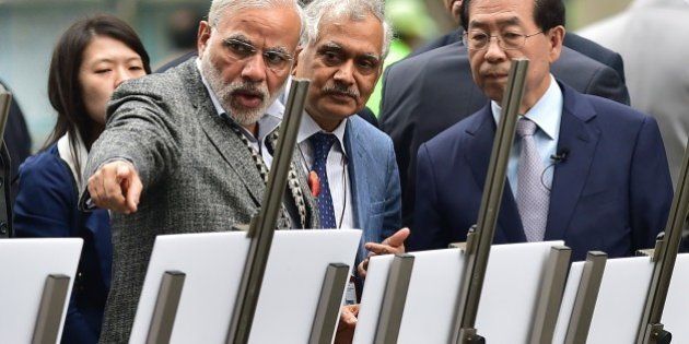 Indian Prime Minister Narendra Modi (L) talks with Seoul Mayor Park Won-Soon (R) as he visits the Cheonggye stream in central Seoul on May 19, 2015. Modi called on South Korea to be a 'leading partner' in his country's economic modernisation as he talked up investment opportunities at the start of a two-day visit. AFP PHOTO / JUNG YEON-JE (Photo credit should read JUNG YEON-JE/AFP/Getty Images)