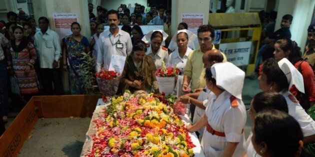 Indian nurses and hospital staff gather to pay their respect near the body of nurse Aruna Shanbaug at a hospital in Mumbai on May 18, 2015. Shanbaug died on May 18 after 42 years in a coma following a brutal rape, in a case that led India to ease some restrictions on euthanasia. AFP PHOTO/ PUNIT PARANJPE (Photo credit should read PUNIT PARANJPE/AFP/Getty Images)