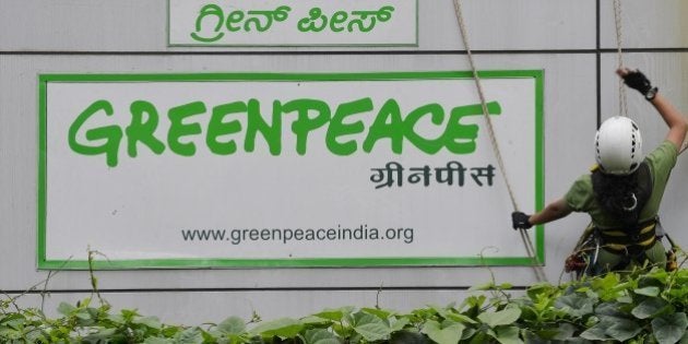 Activists of GreenPeace rappell down their office building where they are head quartered to unfurl banners 'democracy' and 'freespeech' in Bangalore on May 15, 2015. Greenpeace India, which is on the verge of closing down after the Indian government blocked its domestic accounts, is planning to appeal to the judiciary for relief. The NGO recently told its employees that the threat of an imminent shutdown is looming large as it has been left with cash reserves for salaries and office costs for just about a month. AFP PHOTO/ Manjunath KIRAN (Photo credit should read Manjunath Kiran/AFP/Getty Images)