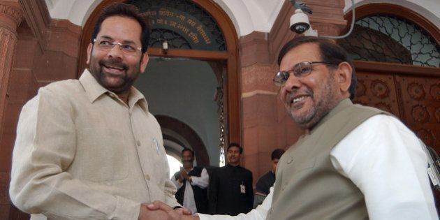 Bharatiya Janta Party leader Sayeed Mukhtar Abbas Naqvi, left, shakes hands with Janata Dal (United) leader Sharad Yadav at the Indian parliament in New Delhi, India, Friday, Nov. 25, 2005. The Indian parliament was adjourned Friday after the opposition National Democratic Alliance demanded resignation of former foreign minister Natwar Singh and Congress Party president Sonia Gandhi over the Iraqi oil-for-food report. (AP Photo/Ajit Kumar)