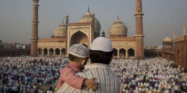 An Indian man carries a child as they gather to offer prayers at Jama Masjid mosque in New Delhi, India, Monday, Oct. 6, 2014. Muslims around the world celebrate Eid al-Adha, or the Feast of the Sacrifice, to commemorate the prophet Abraham's offering for his son to god. (AP Photo/Bernat Armangue)
