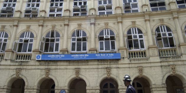 A fire fighter passes by a heritage building, which houses State bank of India, after it was partially damaged in a fire in Bombay, India, Sunday, April 16, 2006. No casualties were reported. (AP Photo/Aijaz Rahi)