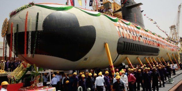 Indian employees of the Mazgaon ship building yard gather around the first Scorpene submarine before it is floated for sea trials in Mumbai on April 6, 2015. The submarine is due for induction into the Indian naval fleet in September 2016. AFP PHOTO/STR (Photo credit should read STR/AFP/Getty Images)