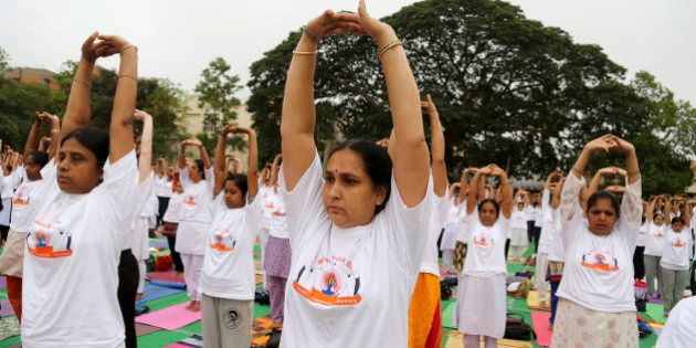 Yoga enthusiasts perform Surya Namaskar or sun salutation as they celebrate World Yoga Day in Bangalore, India, Saturday, June 21, 2014. The event was organized to create awareness among people about the benefits of yoga. (AP Photo/Aijaz Rahi)