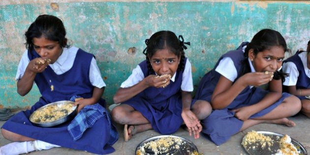 Indian schoolchildren eat their mid-day meal at a government primary school in the outskirts of Hyderabad on June 13, 2011, on the opening day of the new academic year. The government of India's Andhra Pradesh state has introduced English as a second language from Class 1 onwards for the 2011-2012 academic year. India's National Knowledge Commission has admitted that no more than one percent of country's population uses English as a second language. AFP PHOTO/Noah SEELAM (Photo credit should read NOAH SEELAM/AFP/Getty Images)