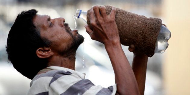 An Indian drinks water from a bottle on a hot summer day in Allahabad, India, Sunday, May 31, 2015. Heat-related conditions, including dehydration and heat stroke, have killed more than 2,000 people since mid-April in the southern Indian states of Andhra Pradesh and Telangana, according to state officials. (AP Photo/Rajesh Kumar Singh)