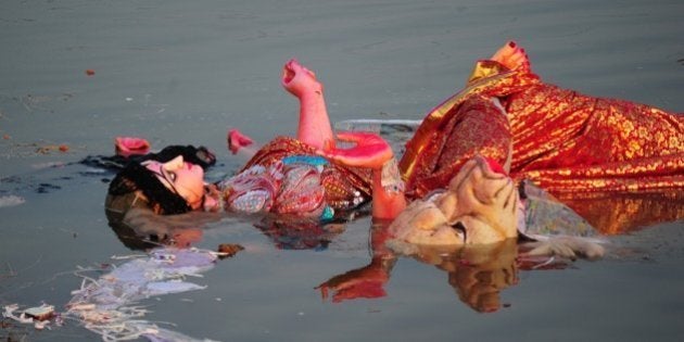 An idol of the Hindu goddess Durga floats in a temporary pond near Sangam after immersion in Allahabad on October 4, 2014. The Durga Puja festival commemorates the slaying of a demon king Mahishasur by goddess Durga, marking the triumph of good over evil. AFP PHOTO/SANJAY KANOJIA (Photo credit should read Sanjay Kanojia/AFP/Getty Images)