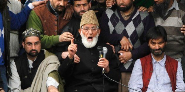 Kashmiri separatist leader Syed Ali Geelani flanked by separatist leaders Yasin Malik, right, and Mirwaiz Umar Farooq, left, speaks during a joint protest against the killing of a teenage boy in Narbal, some 15 Kilometers (10 miles) west of Srinagar, Indian-controlled Kashmir, Monday, April 20, 2015. Relatives and witnesses have contested the official story of the boy's death, saying he had been picked up by authorities and was shot on the side of the road while in custody. Police said in a statement that they arrested two policemen after a preliminary investigation. (AP Photo/Mukhtar Khan)