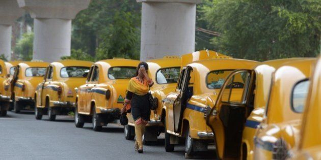 An Indian pedestrian walks past parked taxis in Kolkata on May 25, 2015. More than 430 people have died in two Indian states from a days-long heatwave that has seen temperatures nudging 50 degrees Celsius (122 degrees Fahrenheit), officials said May 25. In the eastern city of Kolkata, taxi unions have urged drivers to stay off the roads between 11am and 4pm because of the heat. AFP PHOTO/ Dibyangshu Sarkar (Photo credit should read DIBYANGSHU SARKAR/AFP/Getty Images)