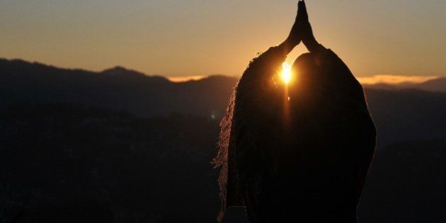 An Indian man performs 'Surya Namaskar' - Salute to the Sun - during the first sunrise of the year 2015 in the northern hill town of Shimla on January 1, 2015. AFP PHOTO (Photo credit should read STRDEL/AFP/Getty Images)