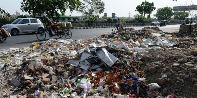 Heap of garbage are strewn along the roadside as sanitation workers strike in New Delhi on June 11, 2015. Sanitation workers with Municipal Corporation of Delhi (MCD), who are on strike over non-payment of salaries for the last three months, have dumped garbage at traffic intersections. AFP PHOTO/PRAKASH SINGH (Photo credit should read PRAKASH SINGH/AFP/Getty Images)