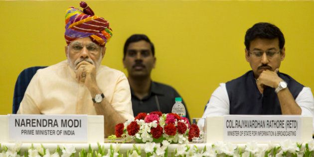 Indian Prime Minister Narendra Modi, left, sits with junior Minister for Information and Broadcasting Rajyavardhan Singh Rathore at the launch of a special television channel for farmers in New Delhi, India, Tuesday, May 26, 2015. Modi's government is marking their first year in office Tuesday. (AP Photo/ Manish Swarup)