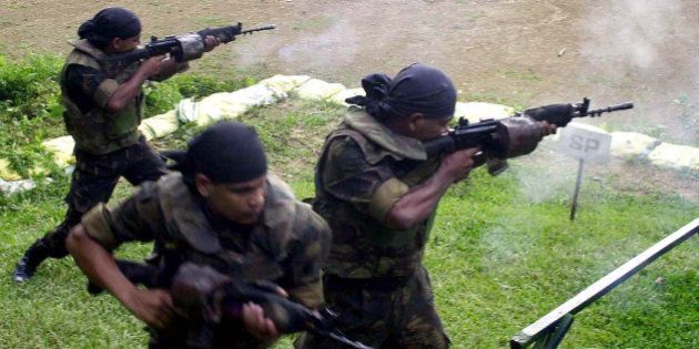 Indian army commandos of Counter Insurgency and Jungle Warfare School (CIJWS) fire during a training session at Vairengte, 60 kilometers (38 miles) north of Aizawal, capital of the northeastern India state of Mizoram, Saturday, Sept. 11, 2004. CIJWS run by the Indian army trains soldiers of India and other parts of the world for counter insurgency operations. (AP Photo/Bikas Das)