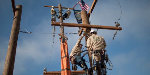 TULARE, CA - FEBRUARY 10: Linemen climb poles at the Southern California Edison exhibit on opening day of the World Ag Expo on February 10, 2015 in Tulare, California. Evan as California moves into its fourth year of historic drought that caused farmers to leave hundreds of thousands of acres of cropland fallow last year, forced some well water-dependent communities to go dry, stressed wildlife and heightened political tensions surrounding water issues, farmers are attending the largest ever World Ag Expo. The expo is the biggest of its kind, attracting an estimated 100,000 visitors from 70 countries to view cutting-edge agricultural technology and equipment at 1,500 exhibits spread across a 2.6 million-square-foot of exhibit area. It is held in one of the most important food producing areas of the nation. (Photo by David McNew/Getty Images)