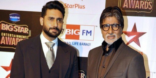 Indian Bollywood film actors Abhishek Bachchan (L) and Amitabh Bachchan attend the 'BIG Star Entertainment Awards' ceremony in Mumbai on December 18, 2014. AFP PHOTO (Photo credit should read STR/AFP/Getty Images)