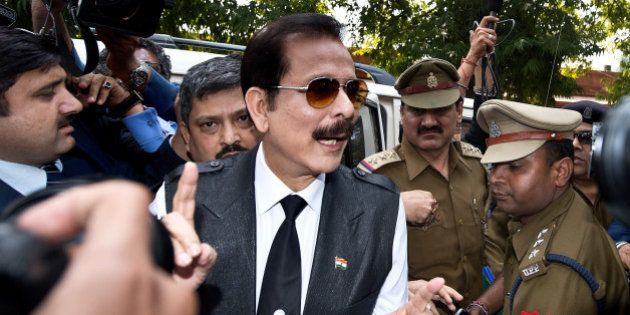 India's Sahara group chairman Subrata Roy (C) speaks to the media as he arrives at the Supreme Court in New Delhi on March 4, 2014. Black ink was thrown on Sahara chairman Subrata Roy's face as he arrived at the Supreme Court , escorted by police personnel. The attacker, who managed to get close to Roy in the crowd and threw black ink on him, claimed to be Manoj Sharma, a lawyer from Gwalior, Madhya Pradesh. Roy was arrested after he failed to respond to the Supreme Court's summons to appear in court in connection with the case in which Sahara owes millions of investors over 22,000 crore Indian rupees (3.5 billion dollars). AFP PHOTO/Prakash SINGH (Photo credit should read PRAKASH SINGH/AFP/Getty Images)