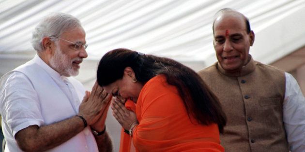 Indiaâs main opposition Bharatiya Janata Party (BJP) leader Vasundhara Raje, center, greets party prime ministerial candidate and chief minister of Gujarat state Narendra Modi, left, and party president Rajnath Singh before her oath taking ceremony as the chief minister of Rajasthan state in Jaipur, India, Friday, Dec. 13, 2013. Raje was Friday sworn-in as the chief minister of the state for the second time. (AP Photo/Deepak Sharma)