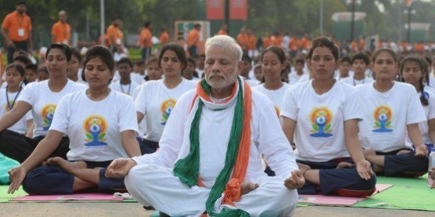 Indian Prime Minister Narendra Modi (C) participates in a mass yoga session along with other Indian yoga practitioners to mark the International Yoga Day on Rajpath in New Delhi on June 21, 2015. Prime Minister Narendra Modi on June 21 hailed the first International Yoga Day as a 'new era of peace', moments before he took to a mat and joined thousands in the heart of New Delhi to celebrate the ancient Indian practice. AFP PHOTO / PRAKASH SINGH (Photo credit should read PRAKASH SINGH/AFP/Getty Images)