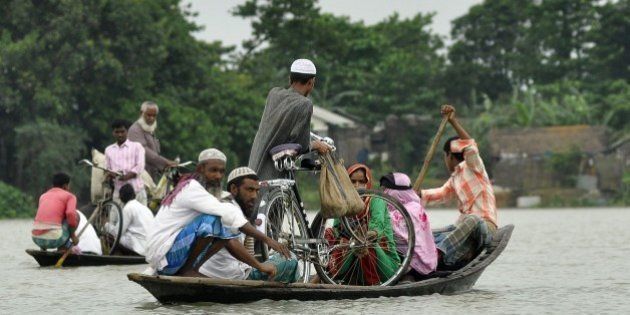 Indian villagers use a boat to travel through floodwater in Pokoriya village, some 75 kms from Guwahati on June 11, 2015. Flooding in India's northeastern state of Assam has reportedly affected some 550 villages in 14 districts, destroying crops and killing at least three people. AFP PHOTO / Biju Boro (Photo credit should read BIJU BORO/AFP/Getty Images)