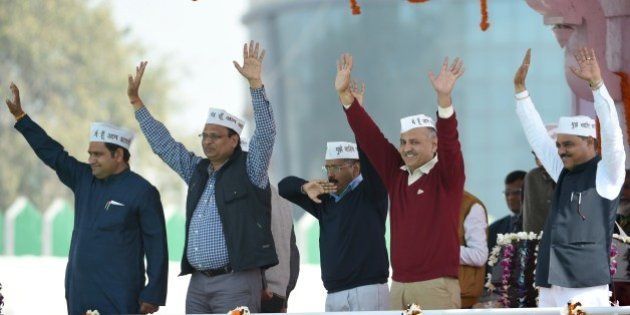 Aam Aadmi Party (AAP) president Arvind Kejriwal (C) and fellow AAP ministers Asim Ahmed Khan (L), Satyendra Jain (2L), Manish Sisodia (2R) and Jitender Singh Tomar greet supporters during his swearing-in ceremony as Delhi chief minister in New Delhi on February 14, 2015. Arvind Kejriwal promised to make Delhi India's first corruption-free state and end what he called its 'VIP culture' as he was sworn in as chief minister before a huge crowd of cheering supporters . AFP PHOTO / PRAKASH SINGH (Photo credit should read PRAKASH SINGH/AFP/Getty Images)