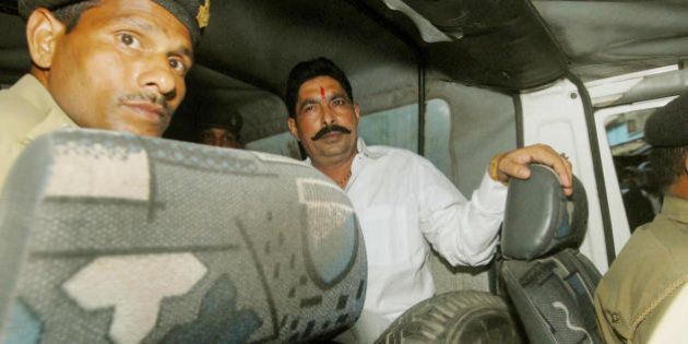 Member of Bihar's ruling Janata Dal (People's Party), Anant Singh (R) waits in the police van on his arrest prior to being sent to Beur Jail in Patna, 01 November 2007. A ruling party lawmaker in India's eastern Bihar state suspected of links to an alleged rape and murder was arrested after his guards and supporters beat up a television crew. A police spokesman in the state capital Patna said Anant Singh, a member of Bihar's ruling Janata Dal (People's Party), was charged with the abduction and assault of a two-member crew from a private television station. AFP PHOTO/ Sonu KISHAN (Photo credit should read STRDEL/AFP/Getty Images)