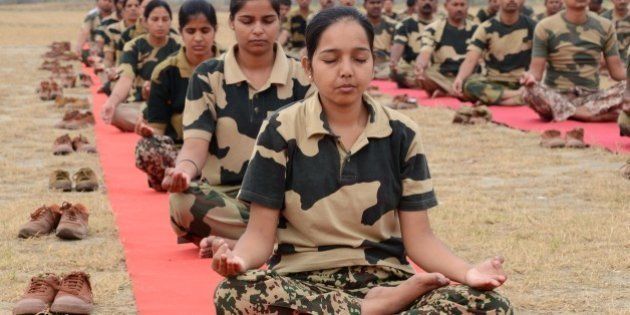 Indian Border Security Force (BSF) personnel perform yoga on International Yoga Day in Khasa on the outskirts of Amritsar on June 21, 2015. Prime Minister Narendra Modi on June 21 hailed the first International Yoga Day as a 'new era of peace', moments before he took to a mat and joined thousands in the heart of New Delhi to celebrate the ancient Indian practice. AFP PHOTO/NARINDER NANU (Photo credit should read NARINDER NANU/AFP/Getty Images)