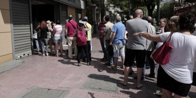 Greeks queue to withdraw cash from an Alpha Bank ATM in central Athens on June 28, 2015. The ECB pledged continued emergency cash for Greece, but no extra help to guard against a feared bank run that could set off financial chaos leading to a euro exit. As the Greek crisis spiralled after talks between Athens and its creditors broke down, Greek citizens have queued at bank machines, heaping pressure on the government to impose capital controls. AFP PHOTO / ANGELOS TZORTZINIS (Photo credit should read ANGELOS TZORTZINIS/AFP/Getty Images)