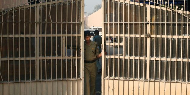 An Indian police officer prepares to close one of the gates at Tihar Jail, the largest complex of prisons in South Asia, in New Delhi, India, Monday, March 11, 2013. Indian police confirmed that Ram Singh, one of the men on trial for his alleged involvement in the gang rape and fatal beating of a woman aboard a New Delhi bus committed suicide at the Tihar jail Monday, but his lawyer and family allege he was killed. (AP Photo/Saurabh Das)