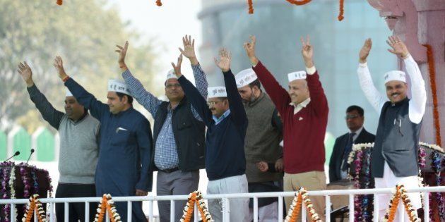 Aam Aadmi Party (AAP) president Arvind Kejriwal (C) and fellow AAP ministers Sandeep Kumar, (L), Asim Ahmed Khan (2L), Satyendra Jain (3L), Gopal Rai, (3R), Manish Sisodia (2R) and Jitender Singh Tomar (R) greet supporters during his swearing-in ceremony as Delhi chief minister in New Delhi on February 14, 2015. Arvind Kejriwal promised to make Delhi India's first corruption-free state and end what he called its 'VIP culture' as he was sworn in as chief minister before a huge crowd of cheering supporters . AFP PHOTO / PRAKASH SINGH (Photo credit should read PRAKASH SINGH/AFP/Getty Images)