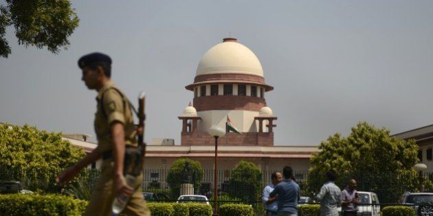A security personel walks in front of the Indian Supreme court in New Delhi on August 27, 2014. India's top court said lawmakers with criminal backgrounds should not serve in government, with 13 ministers facing charges for attempted murder, rioting and other offences. The ruling is likely to put pressure on right-wing Prime Minister Narendra Modi, who swept to power this year pledging clean governance. AFP PHOTO/ SAJJAD HUSSAIN (Photo credit should read SAJJAD HUSSAIN/AFP/Getty Images)