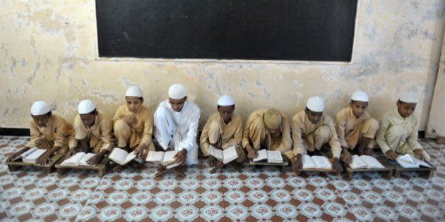 Indian Muslim students recite from the Quran in a classroom during the month of Ramadan at The Madrasa Islamia Darul-Uloom Ashrafia in Hyderabad on June 24, 2015. As well as abstinence and fasting during Ramadan, Muslims are encouraged to pray and read the Quran during Islam's holiest month. AFP PHOTO/NOAH SEELAM (Photo credit should read NOAH SEELAM/AFP/Getty Images)