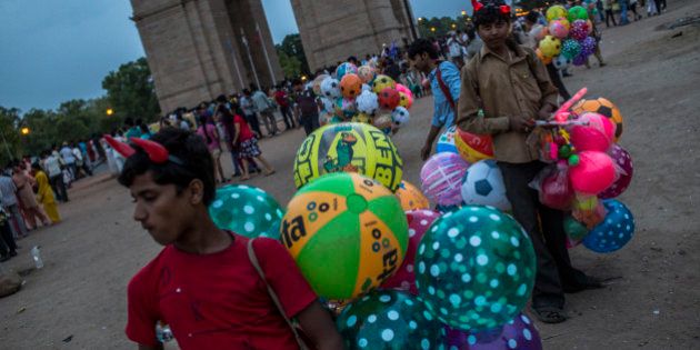 NEW DELHI, INDIA - JUNE 02: Boys selling balloons wait for customers at the India Gate monument on June 2, 2012 in New Delhi, India. A Heat wave continues across the Northern India capital and expects to remain above 40 degrees celsius all week. (Photo by Daniel Berehulak /Getty Images )