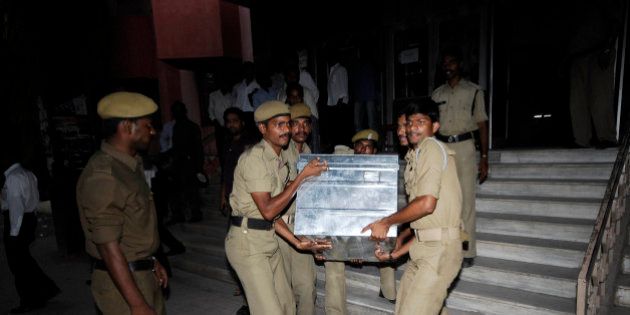 Policemen carry a trunk box containing legal documents relating to the Satyam Computer Services Ltd. fraud case, in Hyderabad, India, Tuesday, April 7, 2009. The Central Bureau of Investigation Tuesday submitted original documents of bank transactions and other documents while filing a charge in the Satyam fraud case against the company's founder B Ramalinga Raju and eight others, according to a news agency. (AP Photo/Mahesh Kumar A.)