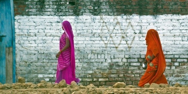 TO GO WITH India-health-women-crime-social,FOCUS BY ABHAYA SRIVASTAVAIn this photograph taken on August 31, 2014, Indian residents return after defecating in an open field in a village in the Badaun district of Uttar Pradesh. Decorated with marigolds and ribbons, 108 toilets unveiled in a tragedy-hit village are a small step in Prime Minister Narendra Modi's push to end open-air defecation for impoverished Indian women. AFP PHOTO/Prakash SINGH (Photo credit should read PRAKASH SINGH/AFP/Getty Images)