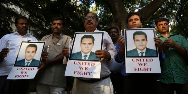 Indian journalists hold candles and photographs of Akshay Singh during a memorial meeting in Bangalore, India, Monday, July 6, 2015. Singh, an Indian television journalist died under mysterious circumstances Saturday while on assignment covering allegations of a massive scheme to manipulate the results of entrance examinations for government jobs and medical colleges in the central Indian state of Madhya Pradesh. The alleged scam labeled âVyapamâ by Indian media after the Hindi name of the stateâs professional examination board since the story first surfaced in 2013. (AP Photo/Aijaz Rahi)