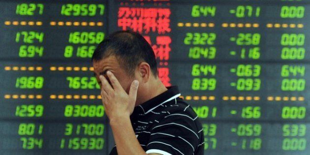 An investor reacts in front of a screen showing stock market movements in Fuyang, eastern China's Anhui province. Chinese shares took another tumble on July 7, defying government efforts to arrest a precipitous fall that has wiped an estimated $3.2 trillion off markets and threatens the world's number-two economy. AFP PHOTO CHINA OUT (Photo credit should read STR/AFP/Getty Images)