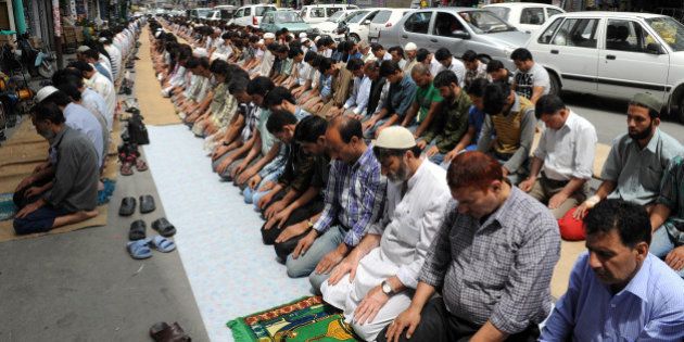 Kashmiri Muslims perform congregational prayers on a street during the first day of the fasting month of Ramadan in Srinagar on July 21, 2012. Muslims fasting in the month of Ramadan must abstain from food, drink and sex from dawn until sunset, when they break the fast with the meal known as Iftar. AFP PHOTO/Rouf BHAT (Photo credit should read ROUF BHAT/AFP/GettyImages)